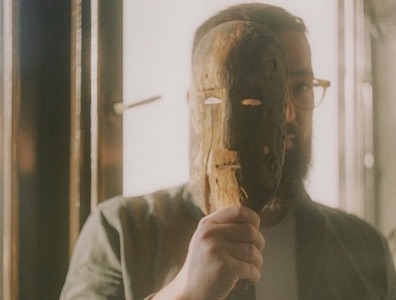 a man holding a wooden mask