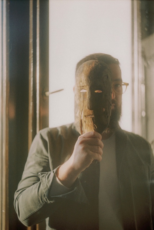 a man holding a wooden mask